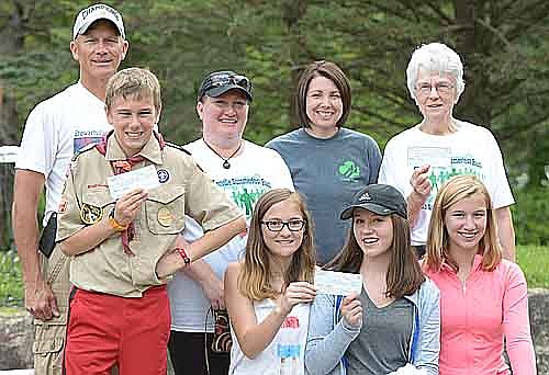 Summerfest Run coordinator Kevin Torgerson (standing, far left) presented checks to, front row, from left, Boy Scout Ethan Stone, Girl Scouts Kaileigh Weber, Maya Ramp and Joey Manning, as well as Kiwanis Diane Berglund (standing, far right). Kendra Weber (standing, second from left) and Angie Manning (standing, second from right) represented the Stewartville Girl Scouts with their daughters.