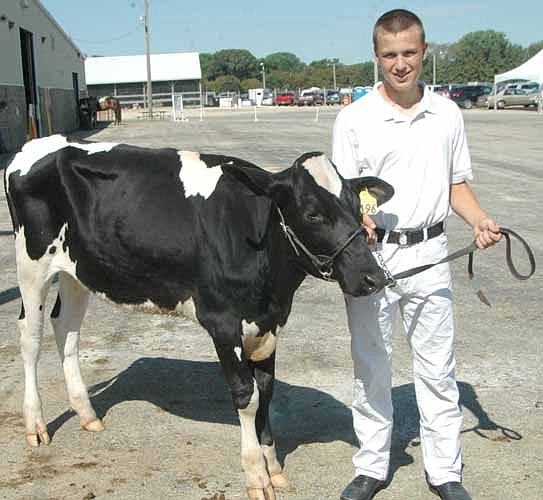 Jacob Twohey poses with his grade fall Holstein calf at the Olmsted County Fair last week. "This is my 10th year (showing at the fair)," he said. "I always look forward to this time."