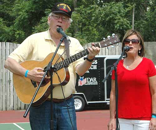Hank Cramer, a retired lieutenant colonel and traveling folk singer from the state of Washington, sang America the Beautiful and The Roseville Fair with Kelly Parkinson, right, at the Miracles Happen military tribute on July 30.