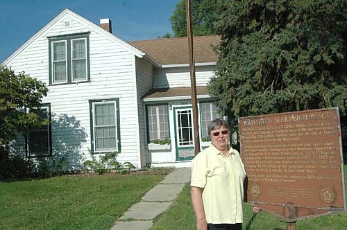 Vicki Meredith, president of the Stewartville Area Historical Society, poses near the Sears House, once the home of Richard Sears, the founder of Sears, Roebuck and Company. The home needs some major repairs, Meredith said.
