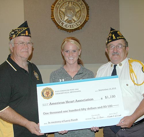 Beth Strobel accepts a $1,150 check for the American Heart Association from Wes Alrick, left, and Roger Peterson.