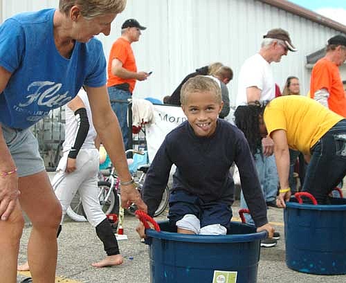 Dayton Hayes of Stewartville, center, concludes his grape stomping effort under the watchful eye of Julie Hayes, Dayton's grandmother, left, at the Fall Festival.