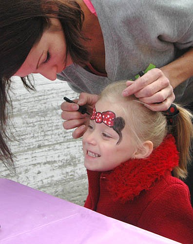 Leyla Meyer, 4, smiles as Sheena Thompson of Stewartville applies Mini Mouse face paint to Leyla's forehead at "Pets in the Park."