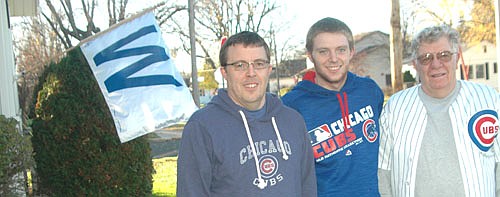 With the "W" for 'win' flag hanging in the background, from left, Bill Rinken, Reese Rinken and Bob Rinken pose for a photo to celebrate the Chicago Cubs' 2016 World Series championship.