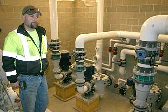 POOL'S PROGRESS -- Sean Hale, lead water operator for the city of Stewartville, above, stands near the recently installed circulation pumps that will carry water to and from the city's new pool, scheduled to be completed this June. "These new pumps will be a lot more maintenance-friendly than the pumps at the old pool," Hale said. "They will regulate themselves so we don't have to mess with them." The new building will also house locker rooms, showers and a concession area. 