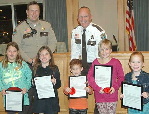 From left, Stewartville children Ashlyn Olson, Zurich Hanson, Cael Szydel, Alivia Szydel and Ava Szydel display the citizen letters of recognition they received at the Olmsted County Sheriff's Office awards ceremony last week. Standing in back are Kevin Torgerson, Olmsted County sheriff, right, who honored the children; and Mike Strelow, Stewartville's community oriented policing (COPS)&#8200;deputy.