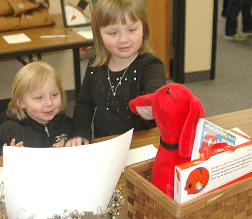 Savannah Stuckey, 6, a kindergartner at Bonner Elementary School, right, and her younger sister Vanessa, 3, a Wee Care student, examine Clifford the Big Red Dog inside a silent auction basket at the annual Wee Care One-Stop Christmas Shop at St. John's Lutheran Church on Saturday, Nov. 19. Hundreds of children and their parents attended the event on Friday evening, Nov. 18 and Saturday, Nov. 19.