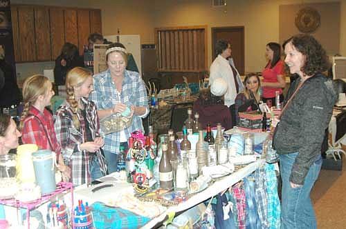 From left, at left, Norah Miland, Cami Elzen and Tonia Elzen welcome shopper Janet Hagen of Stewartville, right, to their booth at the Holidazzle Extravaganza at the Stewartville American Legion Post 164 on Sunday, Nov. 27. The Elzens and Milands sold handmade crafts, Mason jars, home decor and more.