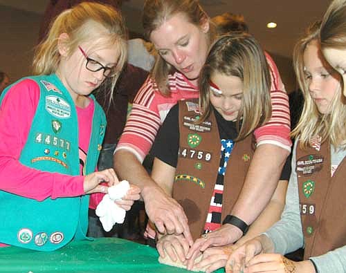 Alysia Struhar, second from left, helps Sydney Klar, 8, a third grader at Bonner Elementary School and a member of Troop 44759, with a project at a Girl Scout Christmas craft-making event at the Stewartville American Legion Post 164 on Friday evening, Dec. 2. Katy Struhar, 9, Alysia's daughter, a fourth grader at Bear Cave Intermediate School and a member of Girl Scout Troop 44577, is at left.