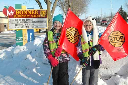 Emma Zahradnik, left, and Addie Haugen, third graders at Bonner Elementary School, worked as School Patrol crossing guards near the school on Wednesday, Jan. 13. Both said they enjoy their job. "It's fun to stop cars," Emma said.