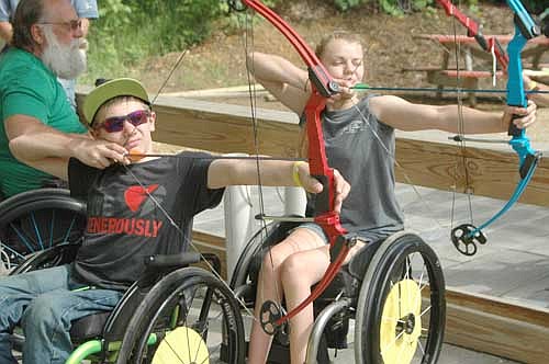 Campers Jace Hanson of Fosston, Minn., left, and Brynn Duncan of Moorhead, Minn., zero in on the target during archery practice at the National Wheelchair Sports Camp at Ironwood Springs Christian Ranch on Wednesday, June 15.