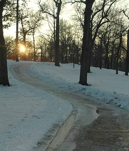 The sun appears to be just a small starburst as it sets just above a path that runs past the snow and the trees at Stewartville's Florence Park last Wednesday afternoon, Jan. 18.