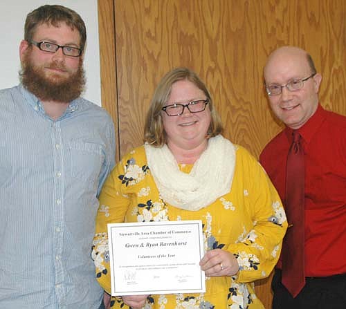 Gwen Ravenhrost, center, and her husband Ryan, left, accept the Chamber Volunteer of the Year Award from Robert  Hruska, right.