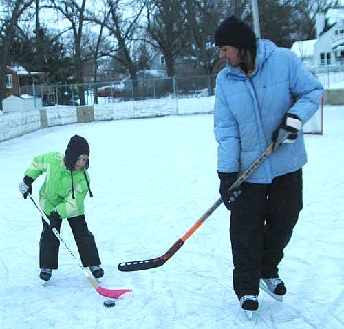 Chanielle Hayes, 6, a kindergartner at Bonner Elementary School, left, controls the puck under the watchful eye of her mother, Sonja Hayes while playing hockey at the Florence Park rink on Tuesday afternoon, Jan. 31.