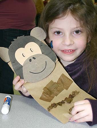 Accompanied by their parents, a total of 190 children attended the annual Stewartville Early Childhood Family Education (SECFE) carnival at the Stewartville High School-Middle School cafeteria on Friday, Feb. 29. Sophia Haglund, 6, of Rochester, displays her completed monkey project. Families that attended donated 408 pounds of food to the Channel One Food Shelf. 