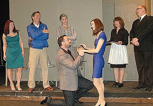 David (Anthony Menz), kneeling, proposes to Sabrina (Rebecca Sands) during a dress rehearsal for the upcoming Stewartville Community Theatre production of Sabrina Fair. Reactions vary among, from left, David's ex-wife Gretchen, (Olivia Renken), brother Linus, (Randy Peterson) mother Maude, (Laurie Helmers) the maid, (Karen Masbruch) and chauffeur (Eldon Anderson).