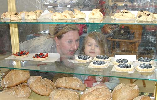 Melanie Shaw of Rochester, left, and her daughter Lacey, 5, take a close look at  the baked goods available at the Stewartville Area Historical Society's Cabin Fever Flea Market, held at the Stewartville Civic Center on Saturday, Feb. 18. Susan Waughtal of Squash Blossom Farm near Douglas, Minn. sold bread, scones and other goodies from a display case at the event.