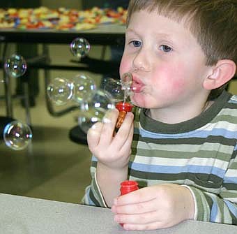 Accompanied by their parents, a total of 190 children attended the annual Stewartville Early Childhood Family Education (SECFE) carnival at the Stewartville High School-Middle School cafeteria on Friday, Feb. 29. Brendt Quandt, 3, a SECFE student from rural Grand Meadow, blows bubbles. Families that attended donated 408 pounds of food to the Channel One Food Shelf. 