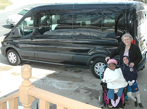 Barbara Fischer and her children, Arianna, seated at left, and AJ gather at the driveway of their Stewartville home near their new van, a 2016 Ford Transit 350. Fischer is very thankful to the 206 families, individuals and/or organizations that donated a total of $36,000 for the new van. "We got donations of $2 to $5,000 from people everywhere," she said.
