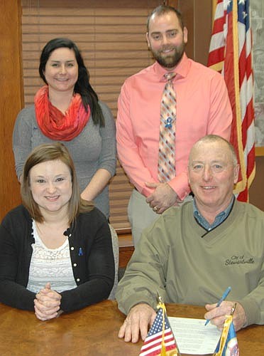 Mayor Jimmie-John King, seated at right, signed a proclamation last week declaring April "Child Abuse Prevention Month" in Stewartville. Allison Johnson, coordinator of the Crisis Nursery for Families First of Minnesota, is seated at left. Standing, from left, are Joelle Marturano, Crisis Nursery intern; and Rick Fakler, a Voices for Children committee member.