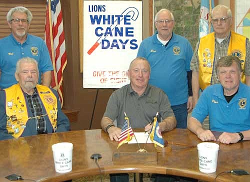 The Stewartville Lions Club will raise money to fight blindness and other eye diseases with its annual White Cane Days this Friday, April 28. Mayor Jimmie-John King, a member of the Lions Club, seated in center, signed a proclamation last week declaring April 28 White Cane Day in Stewartville. Other Lions who will help with the project include, front row, from left, George Menshik, chair of White Cane Days, and Dr. David Thompson. Back row, from left, Bob Fauver, Steve Sturm and Frank Weber.