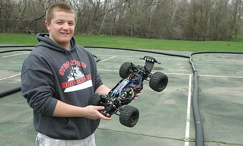 Ben Zahradnik displays the inner workings of his Traxxas 1/10th-scale SLASH&#8200;4x4 truck, which has the potential to reach speeds of up to 60 miles per hour, before he races it at the new RC racetrack at Meadow Park North.