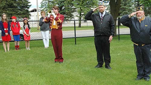 Carter Mintey plays taps at the St. Bernard's Catholic Church cemetery as Jeremiah Oeltjen of the Sons of the American Legion, second from right, and Thom Blade, former commander of Stewartville American Legion Post 164, salute America's fallen heroes.