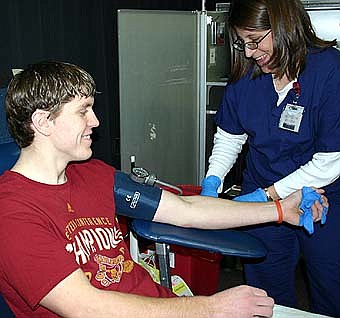 GIVING OF HIMSELF -- Matt Nielsen, a senior at Stewartville High School, is one of many high school students who gave blood during the Mayo Clinic blood drive at the school last week. Kris Borth, donors services technician at the Mayo Clinic, prepares Nielsen for the donation. 
