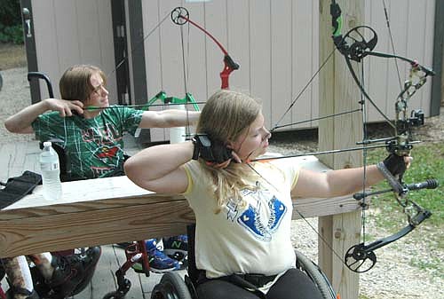 Blake Eaton of Proctor, Minn., left, and Emily Sullivan of Le Sueur, Minn., zero in on the target during archery practice at the National Wheelchair  Sports Camp at Ironwood Springs Christian Ranch on Monday, June 12. For more details about the camp, held June 9-15, see the photo on Page 2 and a story. 