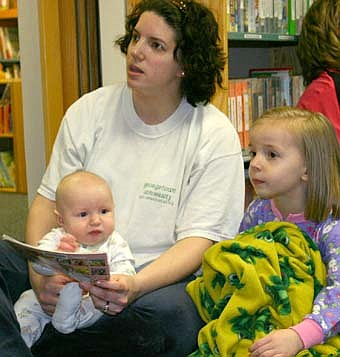 A GOOD STORY -- Pat Johnson, director of the Stewartville Public Library read stories to an attentive audience of Wee Care students and parents during the library's Wee Care Family Night on Tuesday, March 11. Here, Denise Engel, who was accompanied by children Sarah, Ashley and Braden, pauses before sharing from a book.  