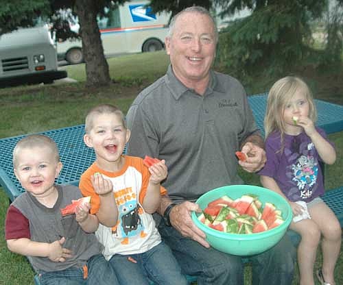 Mayor Jimmie-John King celebrated National Night Out by sharing a bucket of watermelon with three young friends at the Stewartville Public Library on Tuesday evening, Aug. 1. The children are, from left, David Daniels, 1; Nathan Daniels, 3; and Solara Gebhardt, 3, all of Stewartville.