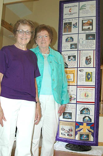 Renee Wilson, left, and Margaret Lex  stand with the embroidered banner highlighting the history of SUMC.