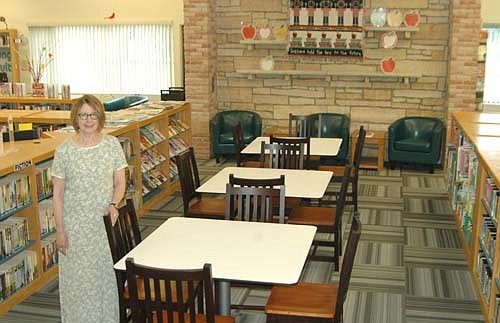 Pat Johnson, library director, stands inside the Stewartville Public Library, furnished with new tables, chairs and carpeting in late July. The tables, which came to the library courtesy of a private donation, brighten the space and are easy to move from place to place, Johnson said. The chairs, from Hom Furniture, Rochester, are durable, stable and easy to clean, she said. Library patrons, staff and members of the Library Board chose the new carpeting, from Hiller's Flooring America of Rochester. Visitors like the changes, Johnson said. "The carpeting is the first thing they talk about," she said.