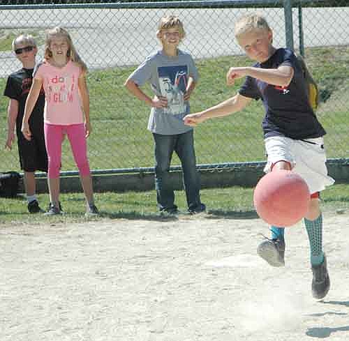  Caden Boehm, 11, a fifth grader at Bear Cave Intermediate School, sends the playground ball on its way during the Old Settlers Day kickball game between the Beasts and the Unicorns. The Beasts won the game by one run.