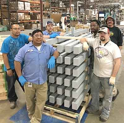 Manufacturing employees at GEOTEK of Stewartville stand near a pallet of crossarms ready for shipment for Hurricane Irma storm relief. GEOTEK shipped more than 5,000 crossarms to help restore power after hurricanes Harvey and Irma swept through Texas and Florida. GEOTEK will host a tour of their company to celebrate Manufacturing Week on Tuesday, Oct. 3.