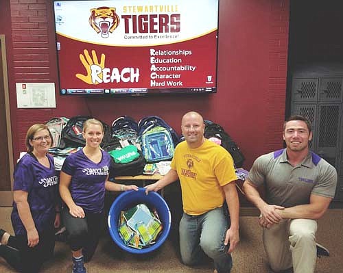 Anytime Fitness of Stewartville raised $500 in August to buy 25 backpacks full of school supplies for children in need. Here, Anytime Fitness of Stewartville employees, from left, Mary Delling, Maggie Kramer and Jared Johnson, far right, present Stewartville REACH program coordinator Jim Perry, third from left, with the backpacks and school supplies.