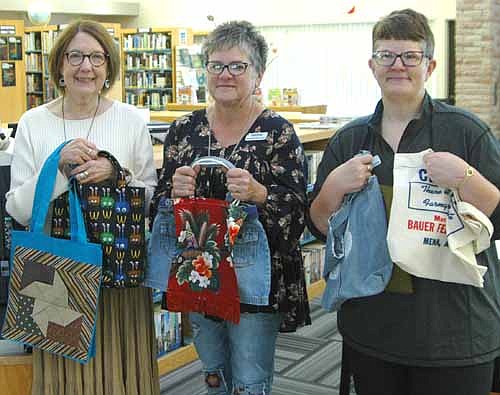 In the near future, the Stewartville Public Library will be required to pay for SELCO plastic book bags. With that in mind, librarians are seeking local and area residents interested in sewing book bags or donating recyclable bags to be used by library patrons. "We would like to involve as many patrons or people willing to help as possible to make this a community project," a statement from the library says. From left, Pat Johnson, library director, and librarians Deb Lofgren and Sue Edge display a few sample bag styles.