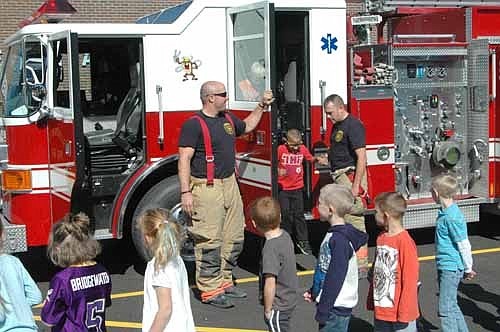 Jack Hagen, 9, a third grader at Bear Cave Intermediate School, operates a fire hose with assistance from Josh Murphy, a Stewartville firefighter, at the Stewartville Fire Department's annual open house on Wednesday, Oct. 11. The event is held in conjunction with Fire Prevention Week.