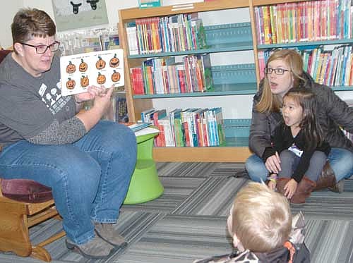 Sue Edge, a librarian at the Stewartville Public Library, left, hosted a Halloween story time at the library on Saturday morning, Oct. 28. As part of her presentation, Edge encouraged those in the audience to make pumpkin faces, which drew an enthusiastic response from Sarah Syhakhoun of Stewartville, right, and her 2-year-old daughter, Celia.