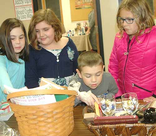 St. John's Lutheran Church hosted its annual One-Stop Christmas Shop to raise funds for the Wee Care Child Care Center on Friday, Nov. 17 and Saturday, Nov. 18. From left, Aubrey Whitacre and Sophie Boyum, both 8-year-olds and second graders at Bonner Elementary School; Jack Whitacre, 6, a kindergartner at Bonner; and Grace Boyum, 10, a fourth grader at Bear Cave Intermediate School, look over the silent auction items on Friday evening, Nov. 17.