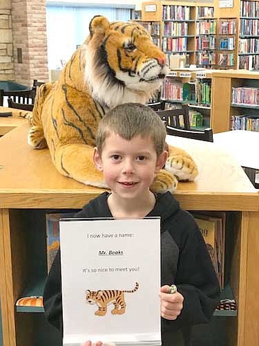 "Mr. Books" is the name of the stuffed tiger on display at the Stewartville Public Library. Parker Carrigan of Stewartville, above, submitted the winning entry in the library's contest to name the tiger.