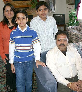 YOUR HOTEL HOSTS  -- Shailesh Patel, seated at right, and his wife Nila, far left, are the owners of Stewartville's Relax Inn. Their sons are Vandan, left, and Hari. 