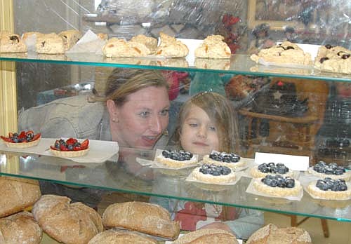 Melanie Shaw of Rochester, left, and her daughter Lacey, 5, examine the baked goods at the Stewartville Area Historical Society's Cabin Fever Flea Market on Feb. 18. Susan Waughtal of Squash Blossom Farm near Douglas, Minn. sold bread, scones and other goodies at the event, held at the Stewartville Civic Center.