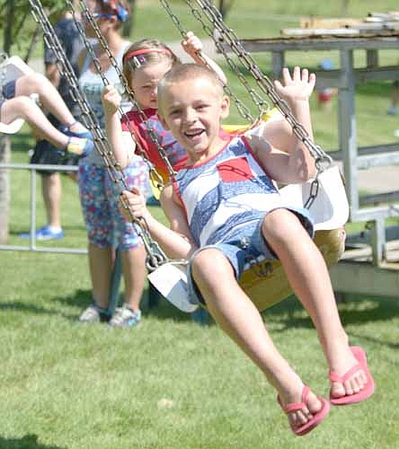 Jackson Schmitz, 6, of Stewartville, smiles and waves as he enjoys the swing ride at the Stewartville Area Chamber of Commerce's Independence Day Summerfest celebration on Tuesday, July 4.