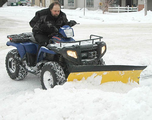 Stephen Biffert, a member of Stewartville Assembly of God Church, uses a Polaris 400 to clear snow near the church after a winter storm left Stewartville and the area covered with about 8 1/2 inches of snow on Sunday, Jan. 21 and Monday, Jan. 22.