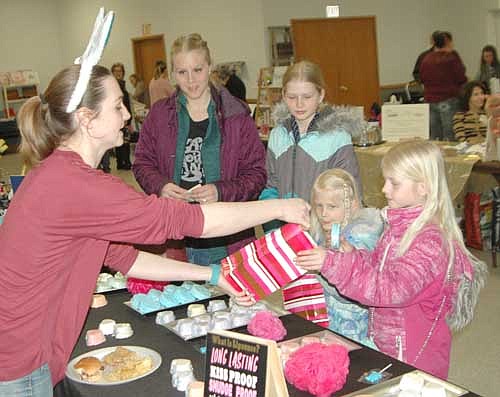Leah Campbell of Stewartville, second from left, and her daughters, from left, Norah, 10, Audrey, 4, and Elise, 7, purchase bath bombs from Anna Serrano, left, owner of Bombs Away, a bath bombs business, at the annual Spring Fling at the Stewartville Civic Center on Saturday, March 24. Hundreds of shoppers browsed among more than 40 booths that day.