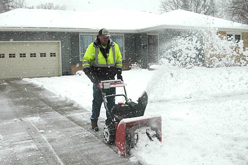 An early-spring storm dumped about seven inches of snow on Stewartville and the area last week, closing local schools on Tuesday, April 3 and causing a two-hour delay on Wednesday, April 4. Kyle Jacobson of Stewartville, above, uses his snowblower to remove snow from the driveway of his neighbor, Mayor Jimmie-John King.