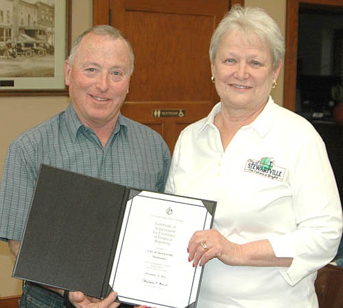 Barb Neubauer, city finance director, right, accepts the Certificate of Achievement for Excellence in Financial Reporting from Mayor Jimmie-John King. Neubauer and the city have earned the award so often that city officials are running out of room for plaques on the walls at City Hall, King said. 