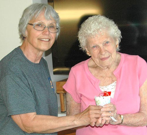 Members of the Stewartville Morning Lions Club, filled May baskets with sweet treats for the residents of the Stewartville Care Center, Stewartvilla Apartments and Root River Estates on May Day, Tuesday, May 1. Here, Shiela Majerus, left, hands a May basket to Evelyn Galligos, a Care Center resident. Galligos said she greatly enjoys life at the Care Center. "I love this place," she said. "Everybody is friendly."