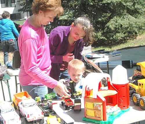 Hundreds of shoppers attended the 34th annual Stewartville Citywide Garage Sale Thursday, May 10 through Saturday, May 12. Here, Krissy Sullivan of Stewartville, standing at right, and her mother, Carol Drees, help Krissy's son Maximus, 4, search for a toy at a sale along Tenth Avenue Northeast last Thursday.